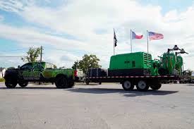 Green refinishing truck and trailer with eco-friendly equipment, showcasing sustainable construction services in Charleston.